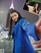 A woman in a blue coat is taking a selfie.