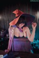 A woman in a witches hat sitting at a table.