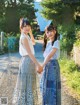 A couple of women standing next to each other on a road.