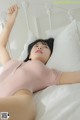 A woman laying on top of a white bed.