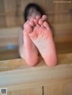 A woman's bare feet in a wooden sauna.