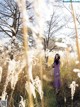 A woman in a purple dress standing in tall grass.