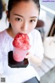 A woman holding a cup of ice cream in her hand.