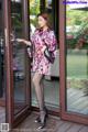 A woman standing in front of a glass door.