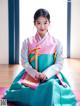 A young girl in a blue and pink hanbok sitting on the floor.